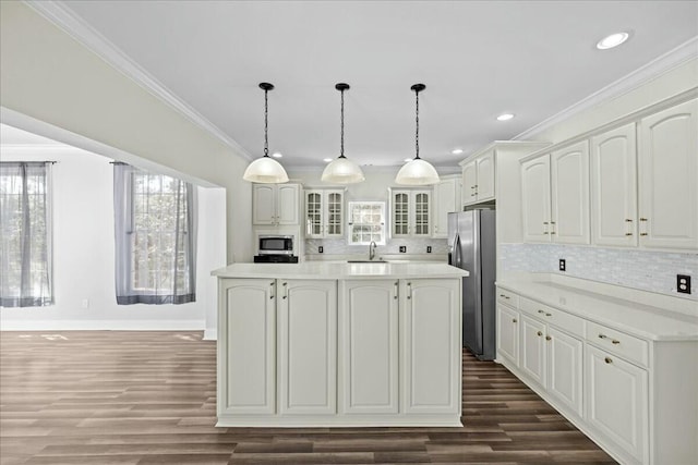 kitchen featuring appliances with stainless steel finishes, a sink, glass insert cabinets, and white cabinetry