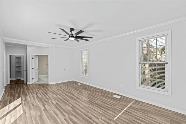 unfurnished room with baseboards, ornamental molding, ceiling fan, and wood finished floors