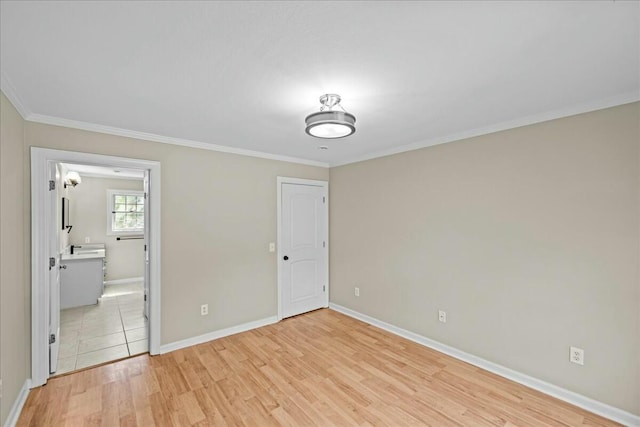 unfurnished bedroom with baseboards, ornamental molding, and light wood-style floors