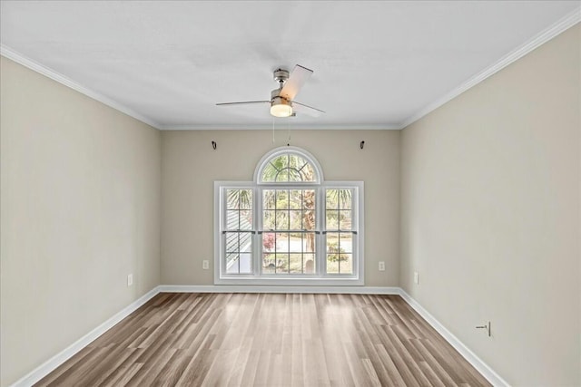 spare room featuring ornamental molding, ceiling fan, baseboards, and wood finished floors