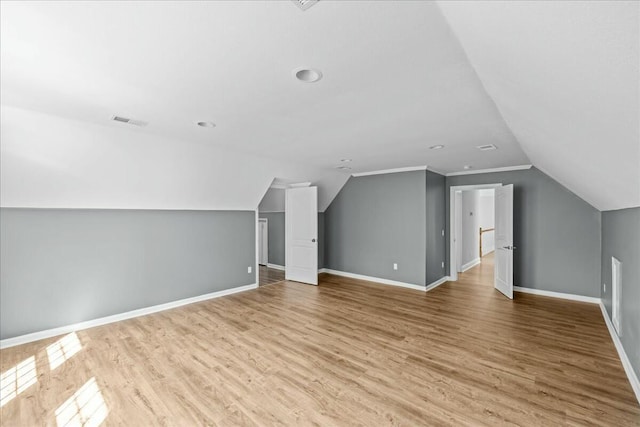 bonus room with vaulted ceiling, wood finished floors, visible vents, and baseboards