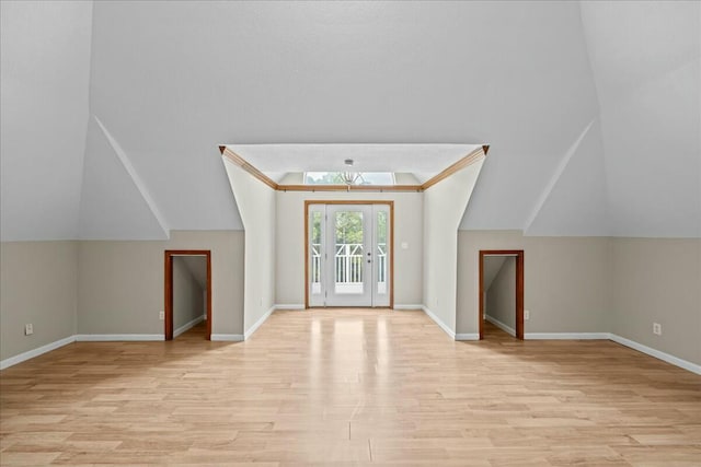 additional living space featuring vaulted ceiling, light wood-type flooring, and baseboards