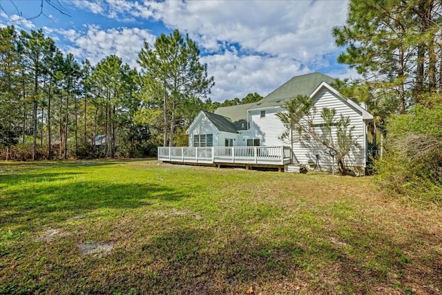 back of house featuring a lawn and a wooden deck