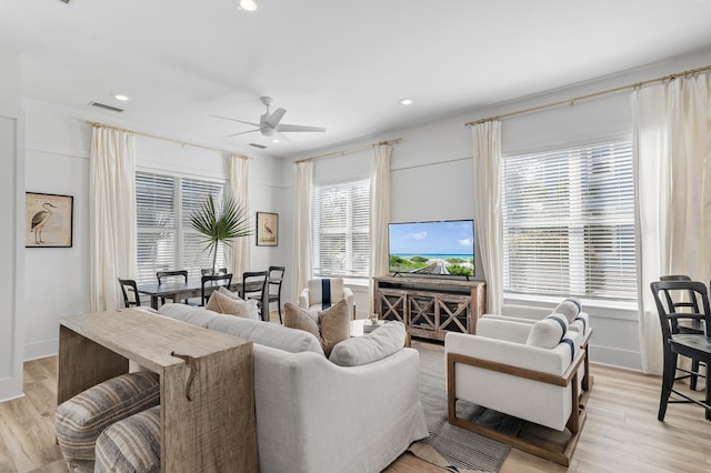 living room with light wood-style flooring, plenty of natural light, and visible vents