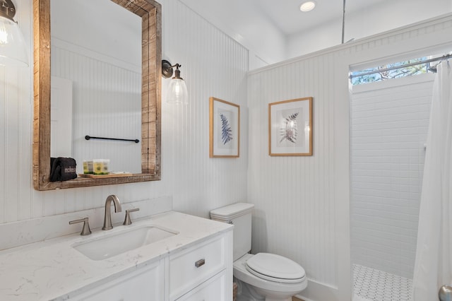 full bath with a tile shower, vanity, and toilet