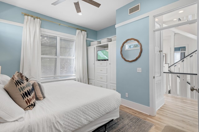 bedroom featuring multiple windows, wood finished floors, visible vents, and baseboards