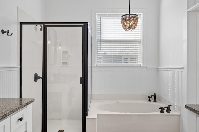 full bath with a garden tub, a wainscoted wall, a stall shower, and vanity