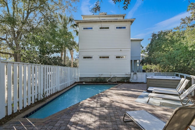 view of pool with a patio, a fenced backyard, and a hot tub