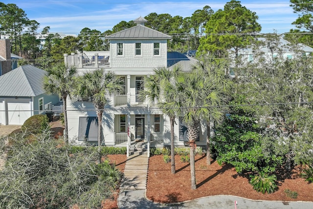 view of front of house featuring a porch, a standing seam roof, and a balcony