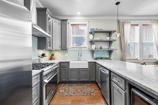 kitchen featuring tasteful backsplash, appliances with stainless steel finishes, gray cabinets, and a sink