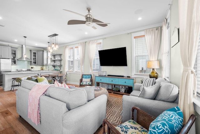 living area with baseboards, a ceiling fan, wood finished floors, and recessed lighting