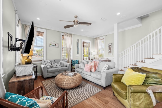 living room with stairs, visible vents, wood finished floors, and a wealth of natural light