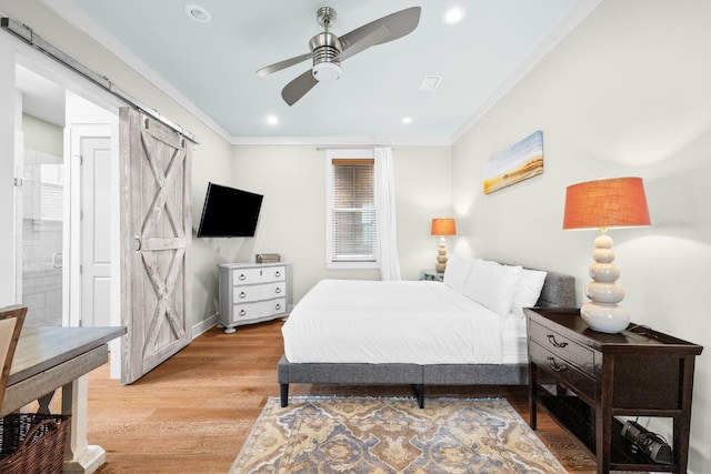 bedroom featuring recessed lighting, a barn door, ornamental molding, light wood-type flooring, and baseboards