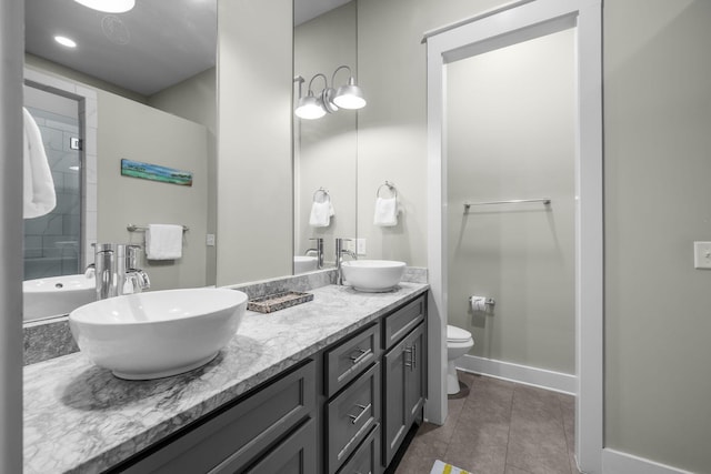 full bathroom with toilet, tile patterned flooring, double vanity, and a sink