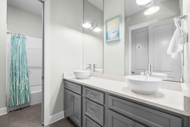 full bathroom featuring double vanity, a sink, baseboards, and tile patterned floors