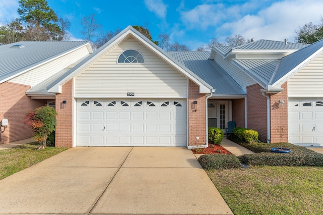 single story home featuring brick siding, concrete driveway, an attached garage, a front yard, and metal roof