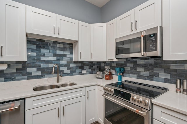 kitchen featuring stainless steel appliances, a sink, and white cabinetry