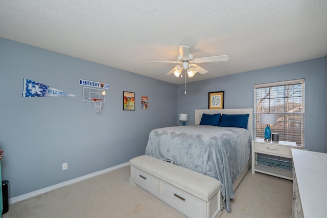 bedroom with ceiling fan, baseboards, a textured ceiling, and light colored carpet