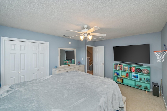 bedroom featuring a closet, visible vents, a ceiling fan, carpet flooring, and a textured ceiling