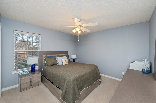 bedroom with light colored carpet, ceiling fan, a textured ceiling, and baseboards