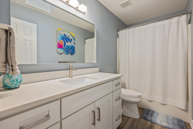 bathroom featuring shower / bath combo, visible vents, toilet, wood finished floors, and vanity