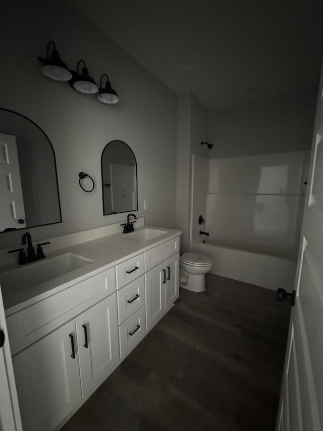 full bathroom with double vanity,  shower combination, a sink, and toilet