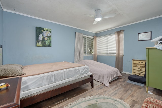 1005 Revere Dr, Pensacola, FL 32506 - bedroom featuring ornamental molding, baseboards, a textured ceiling, ceiling fan, and wood finished floors