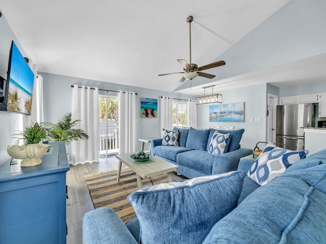 living room with lofted ceiling, light wood-style flooring, and ceiling fan