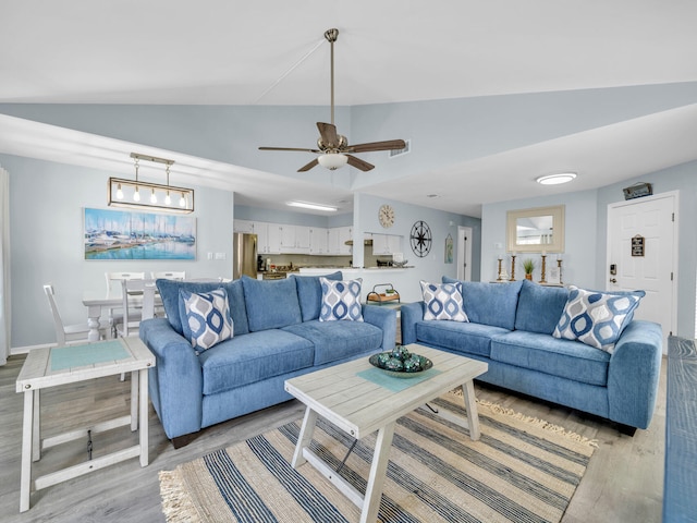 living area with light wood-type flooring, baseboards, vaulted ceiling, and a ceiling fan