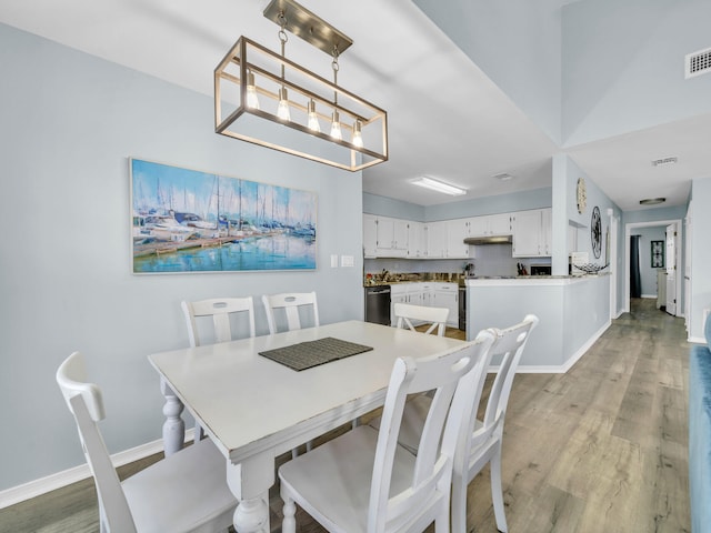 dining space with visible vents, a notable chandelier, light wood-style flooring, and baseboards