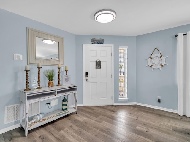 entryway featuring visible vents, baseboards, and wood finished floors