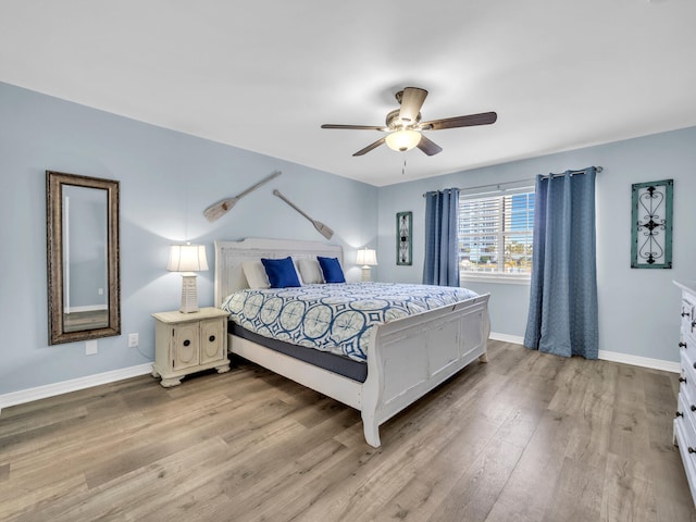 bedroom featuring light wood-style floors, baseboards, and a ceiling fan