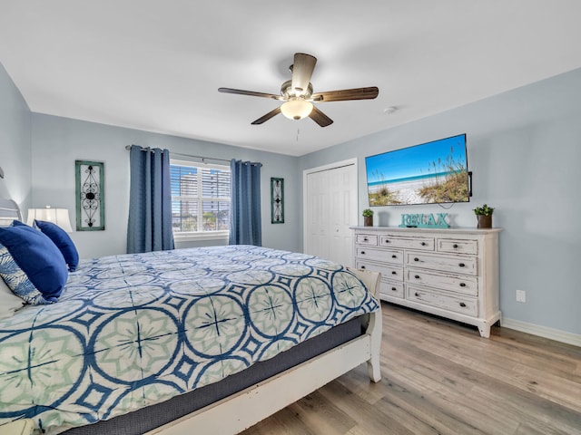 bedroom featuring a closet, wood finished floors, a ceiling fan, and baseboards