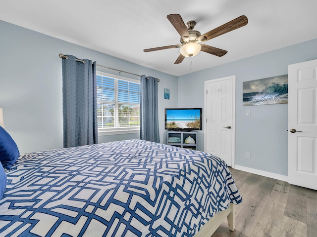 bedroom featuring ceiling fan, baseboards, and wood finished floors