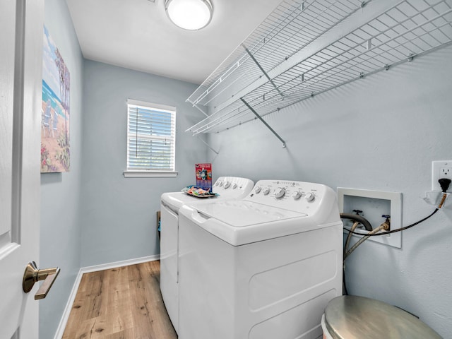 clothes washing area with light wood-style floors, washing machine and dryer, laundry area, and baseboards