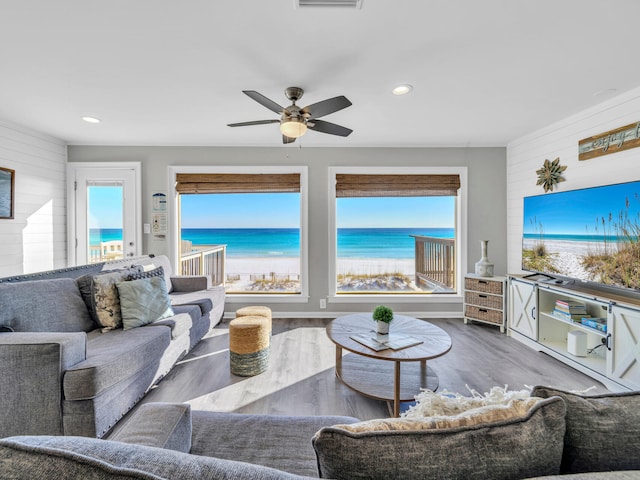 living room featuring a healthy amount of sunlight, wooden walls, and dark wood finished floors