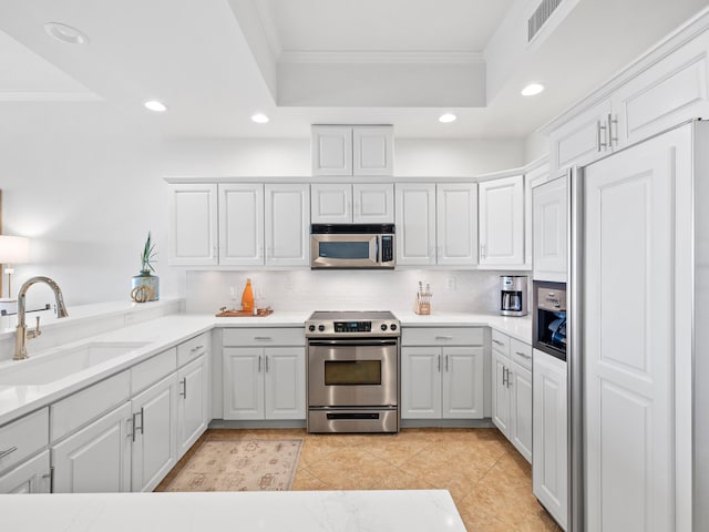 kitchen featuring appliances with stainless steel finishes, a sink, and ornamental molding