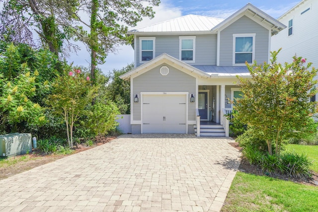 traditional home with decorative driveway, a standing seam roof, and metal roof