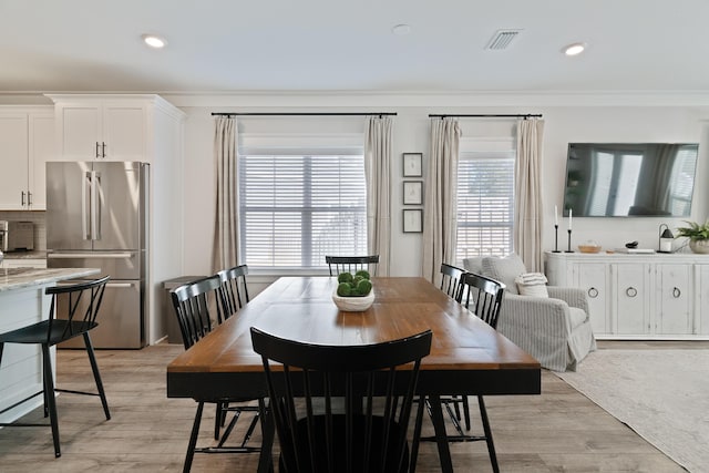 dining area with light wood-type flooring, visible vents, crown molding, and recessed lighting