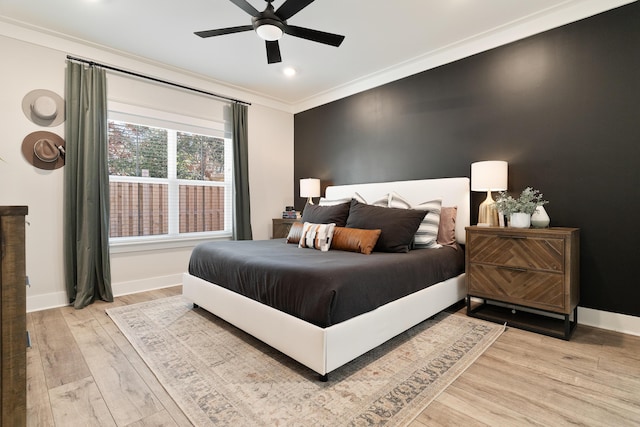 bedroom featuring ornamental molding, light wood-type flooring, ceiling fan, and baseboards