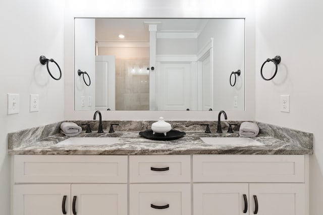 bathroom with double vanity, a tile shower, and a sink