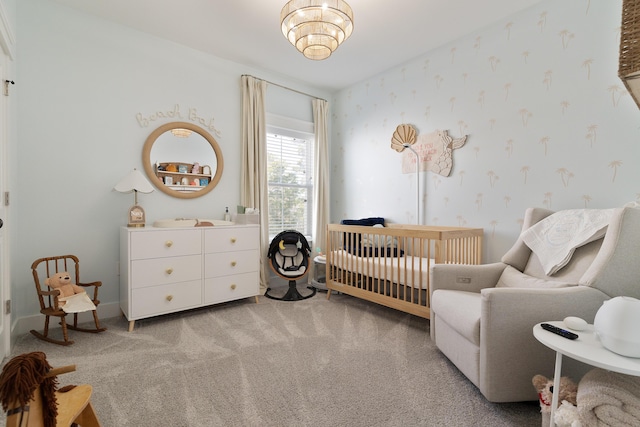 bedroom featuring a nursery area, light colored carpet, baseboards, and wallpapered walls