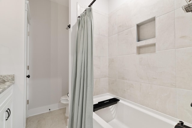 bathroom featuring toilet, shower / bath combo, baseboards, and vanity