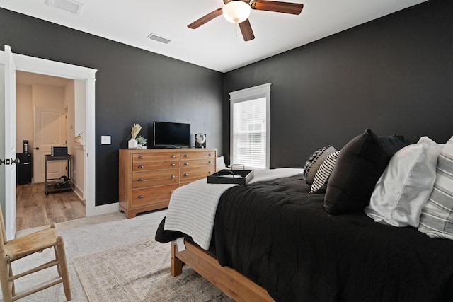 bedroom featuring light colored carpet, visible vents, ceiling fan, and baseboards