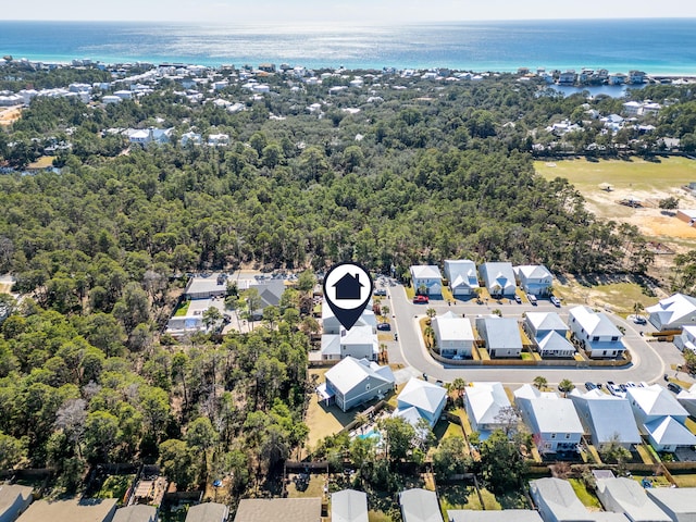 aerial view featuring a forest view, a water view, and a residential view