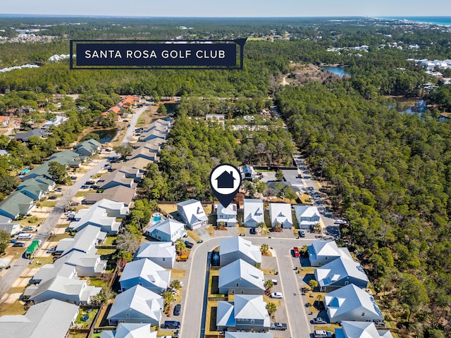 drone / aerial view with a wooded view and a residential view