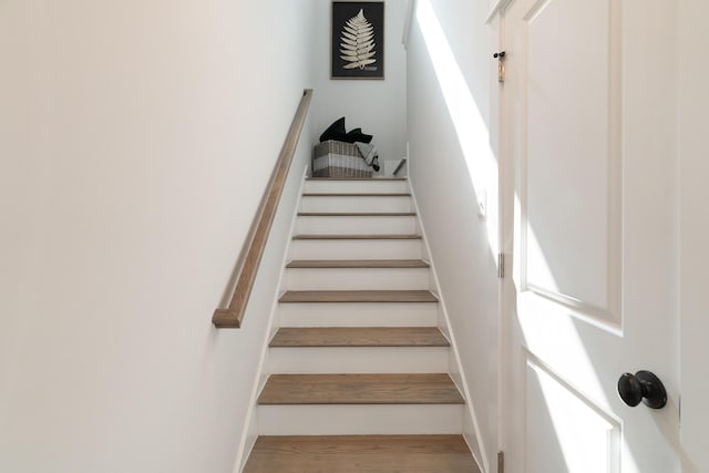 stairway featuring wood finished floors and baseboards