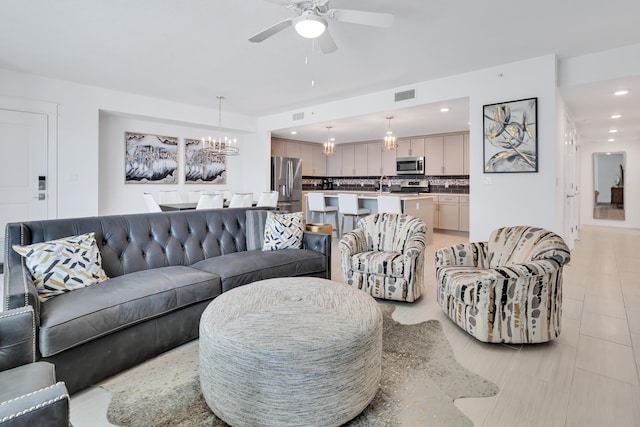 living area featuring ceiling fan with notable chandelier, visible vents, and recessed lighting