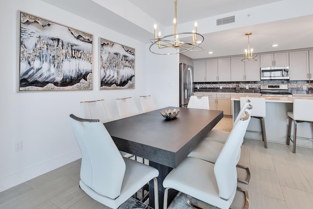 dining room with an inviting chandelier, baseboards, visible vents, and recessed lighting