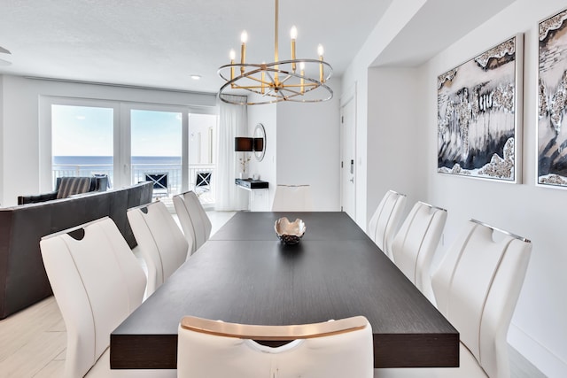 dining space with a water view and a chandelier